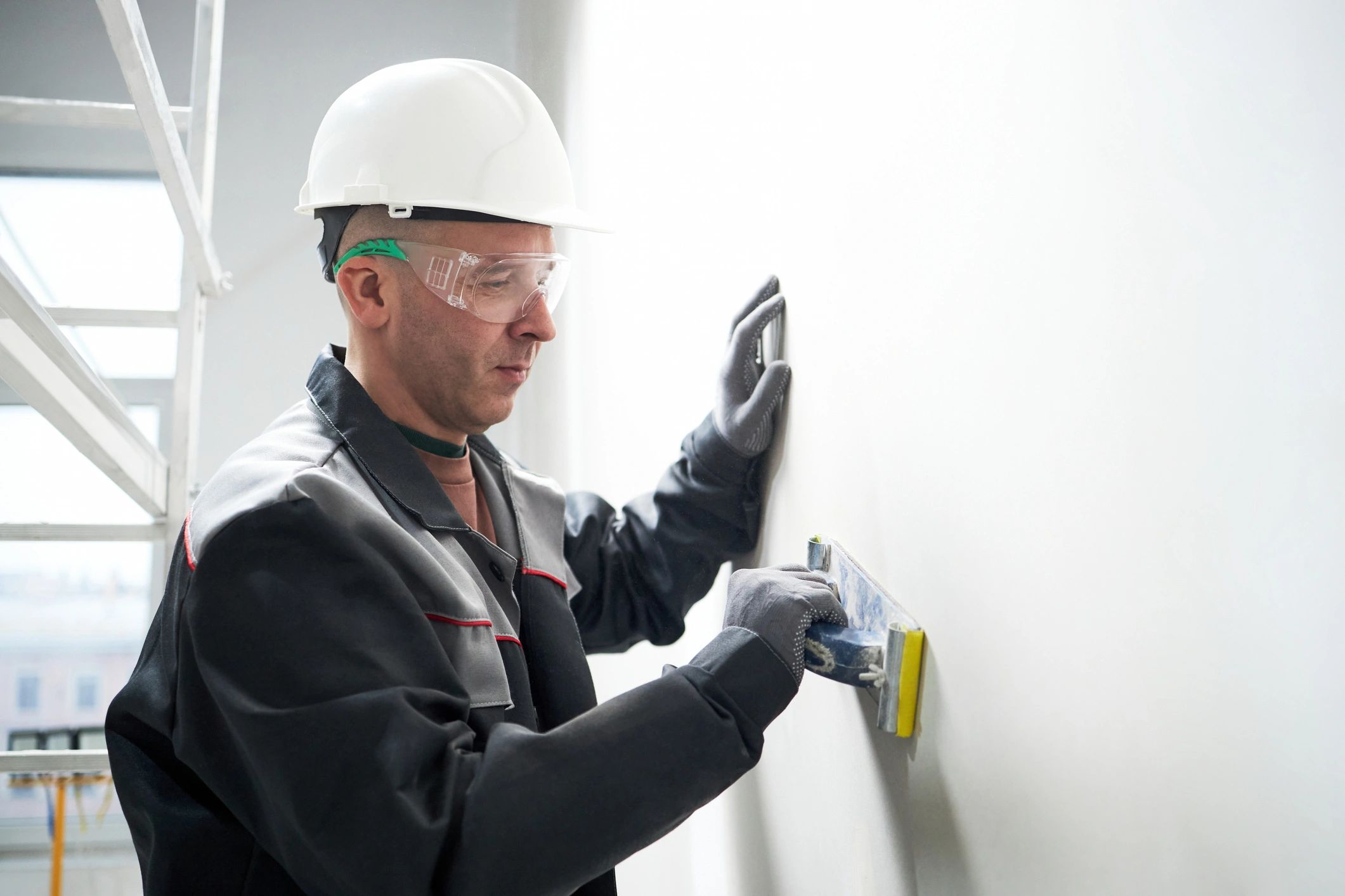 Professional painter preparing and smoothing an interior wall