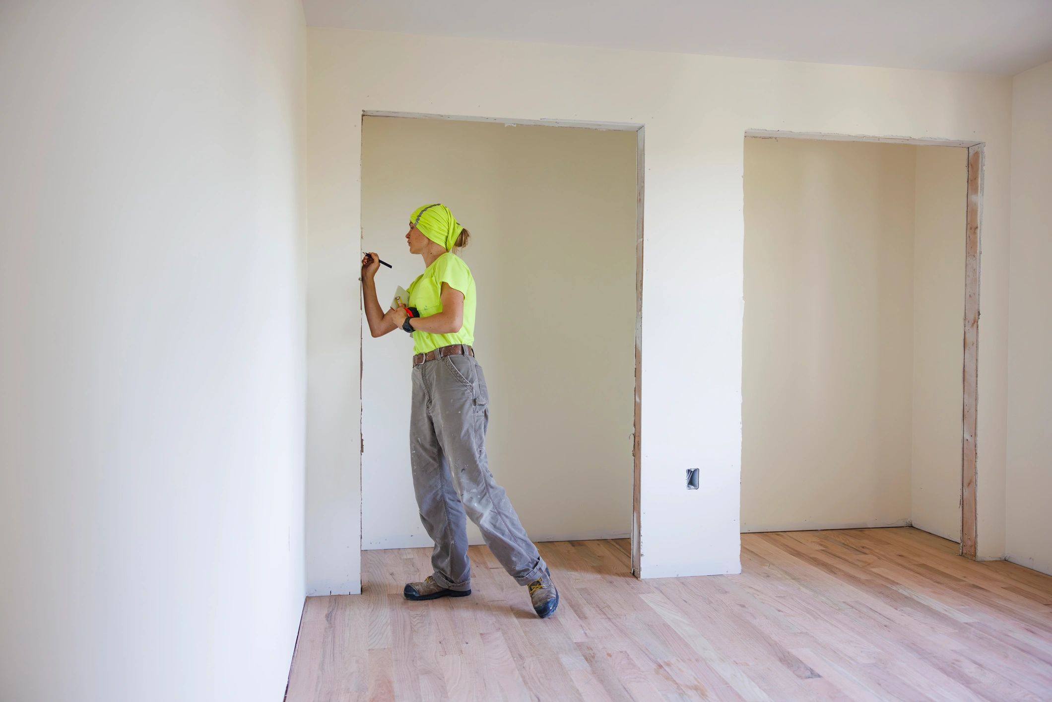 Contractor measuring and assessing an interior project space